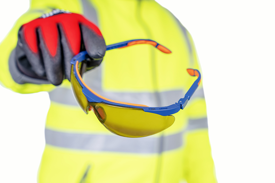 A Builder In A Blue Hat And Yellow Reflective Coat Gives Safety