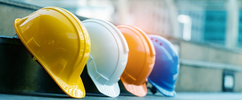 Multicolored Safety Construction Worker Hats. Teamwork Of The Co