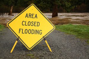Flooding river and road closed sign. Flooding river and road closed sign.